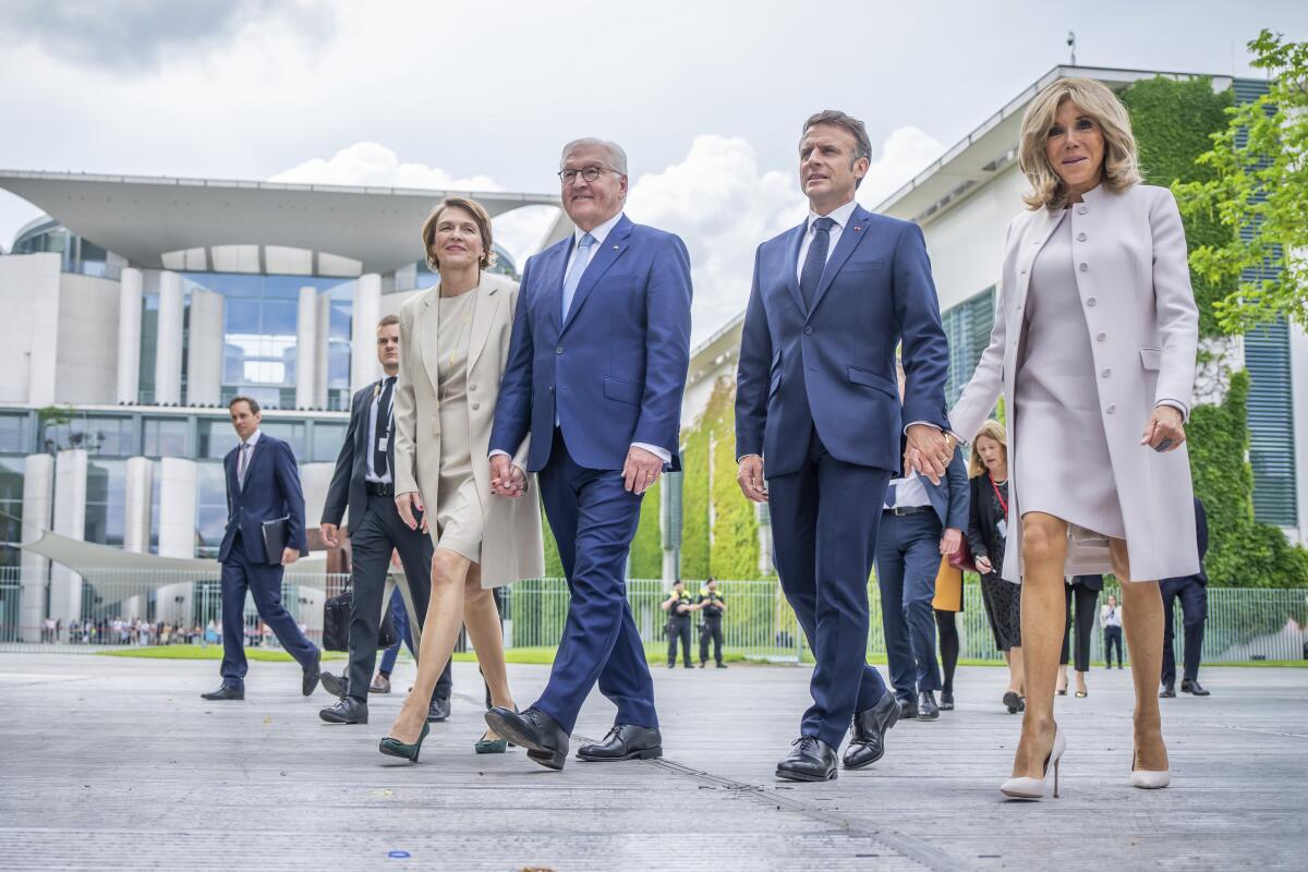 Emmanuel Macron and his wife, Brigitte, walk with Frank-Walter Steinmeier and his wife, Elke Büdenbender.