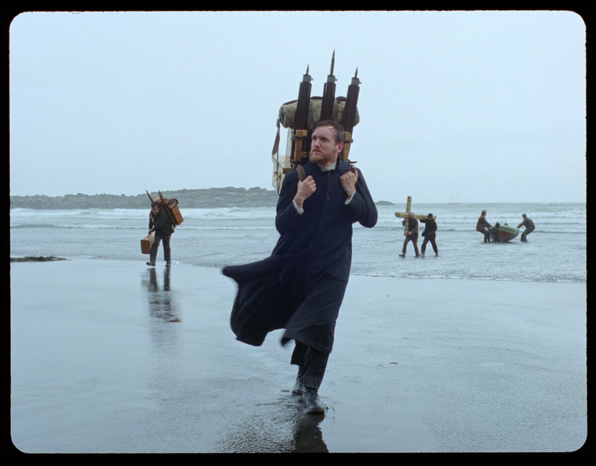 Elliott Crosset Hove carries a heavy load on his back in a scene from the movie "Godland."