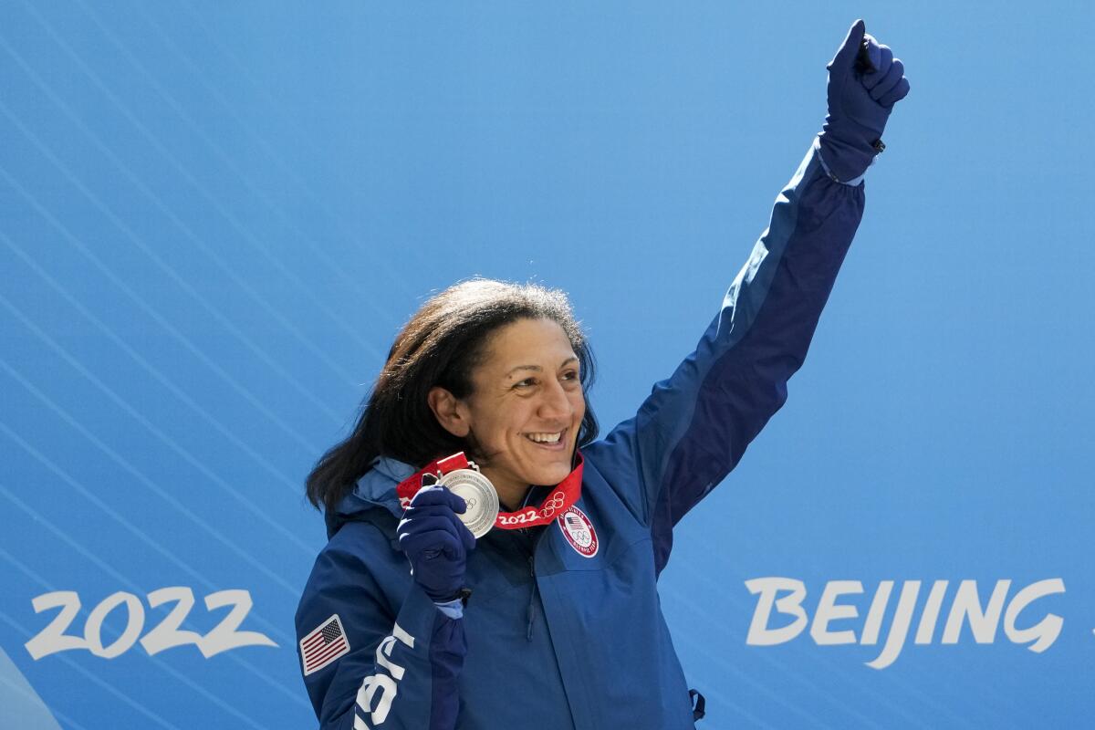U.S. bobsledder Elana Meyers Taylor holds up her silver medal and an arm.