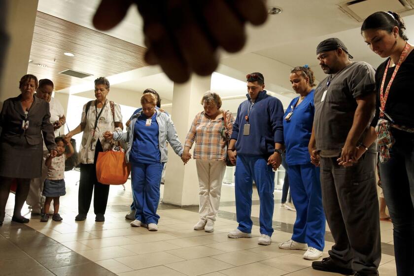 SAN JUAN, PUERTO RICO---SEPT. 26, 2017--Hospital employees and nurses gather to pray for a co-worker who was critically injured in a violent attack during the chaos post-Maria hurricane. At the Centro Medico Puerto Rico (hospital), critical care cases from all over the island are brought for care. It has been a struggle to keep everything working smoothly given the damage done to infrastructure. (Carolyn Cole/Los Angeles Times)