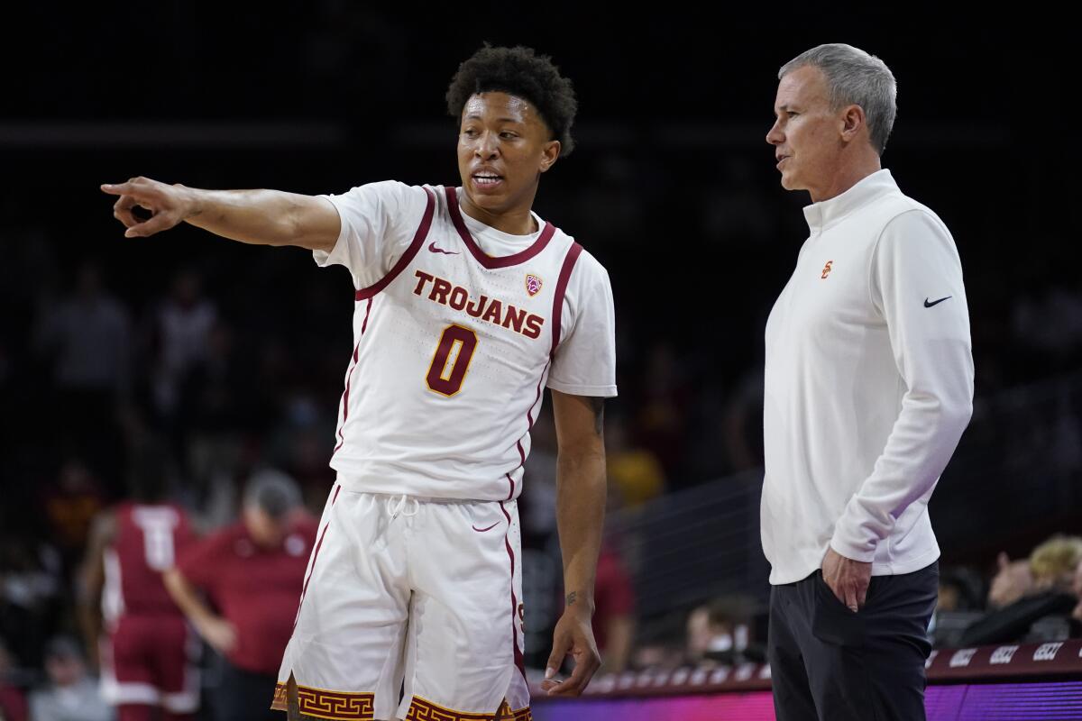 USC guard Boogie Ellis talks to coach Andy Enfield during a game against Washington State on Feb. 20.