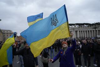 People waves Ukrainian flags before Pope Francis Angelus noon prayer from the window of his studio overlooking St.Peter's Square, at the Vatican, Sunday, March 10, 2024. (AP Photo/Alessandra Tarantino)