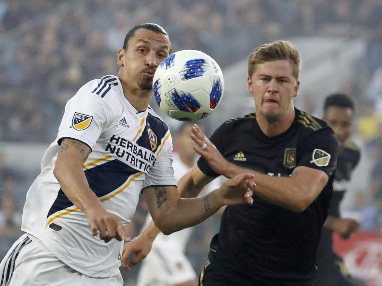 Los Angeles Football Club defender Walker Zimmerman, right, battles Galaxy forward Zlatan Ibrahimovic for control of the ball in the first half at the Banc of California Stadium in Los Angeles.