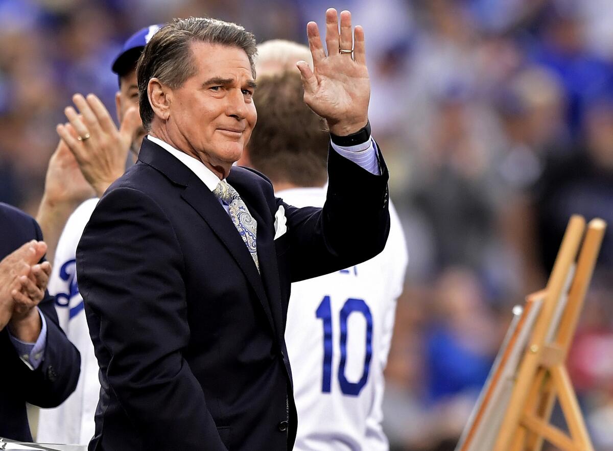 Former Dodger Steve Garvey waves to fans before a baseball game in Los Angeles.