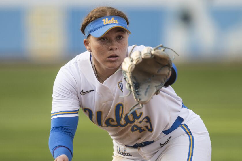 UCLA third baseman Megan Grant (43) catches the ball during an NCAA softball game.