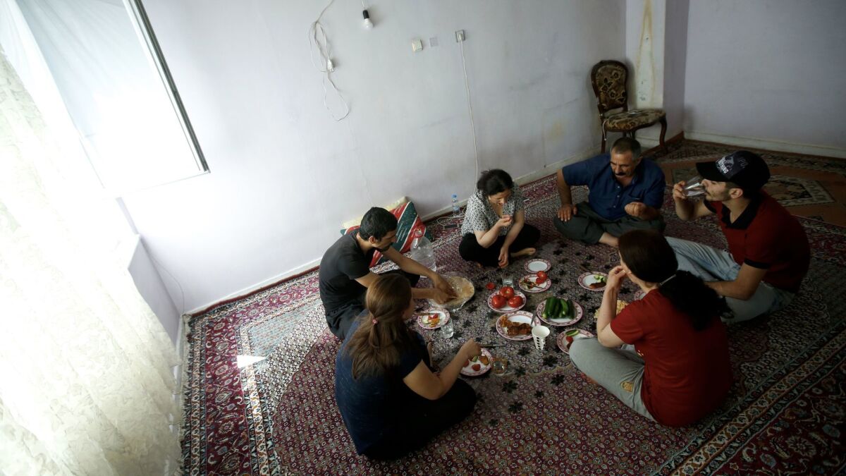 The Moradi family gathers for lunch in an apartment lent by a friend. The Moradis fled from Iran to Turkey and live in the city of Kayseri as they await flights to resettle in the U.S.