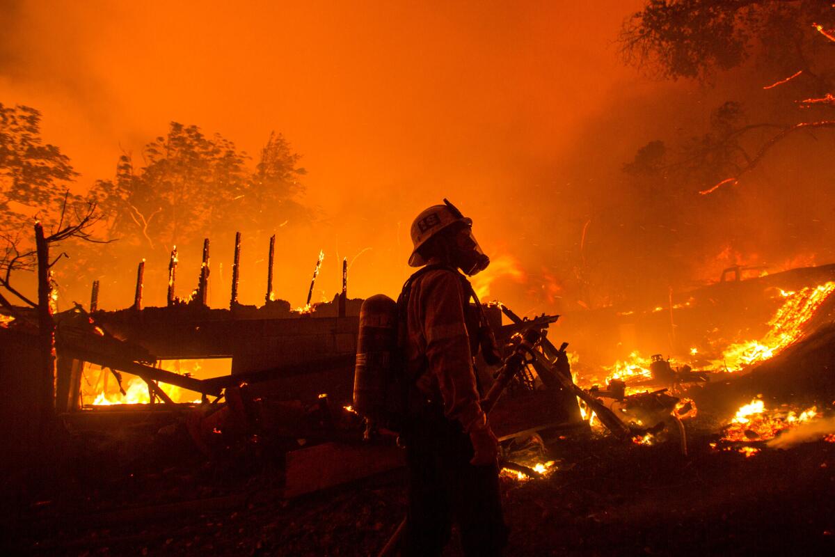 A firefighter surveys damage caused by the Lake fire Wednesday night.