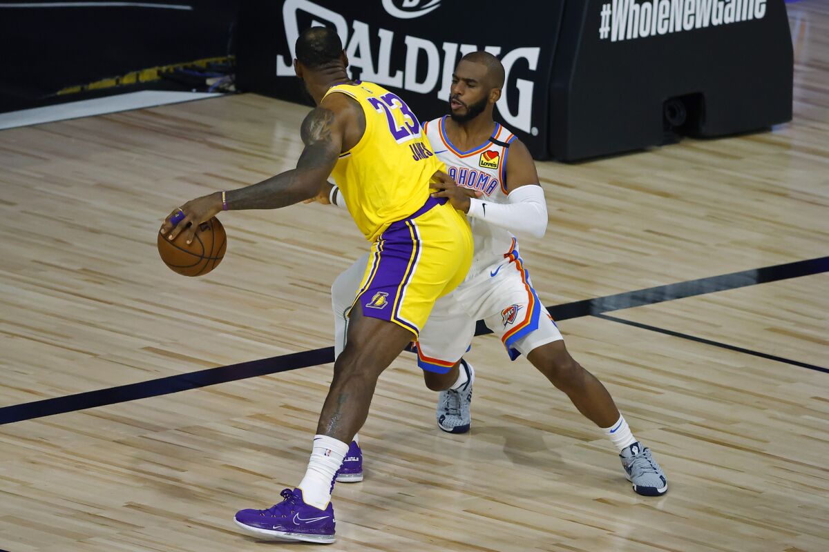 Los Angeles Lakers' LeBron James (23) is defended by Oklahoma City Thunder's Chris Paul during the first half of an NBA basketball game Wednesday, Aug. 5, 2020, in Lake Buena Vista, Fla. (Kevin C. Cox/Pool Photo via AP)