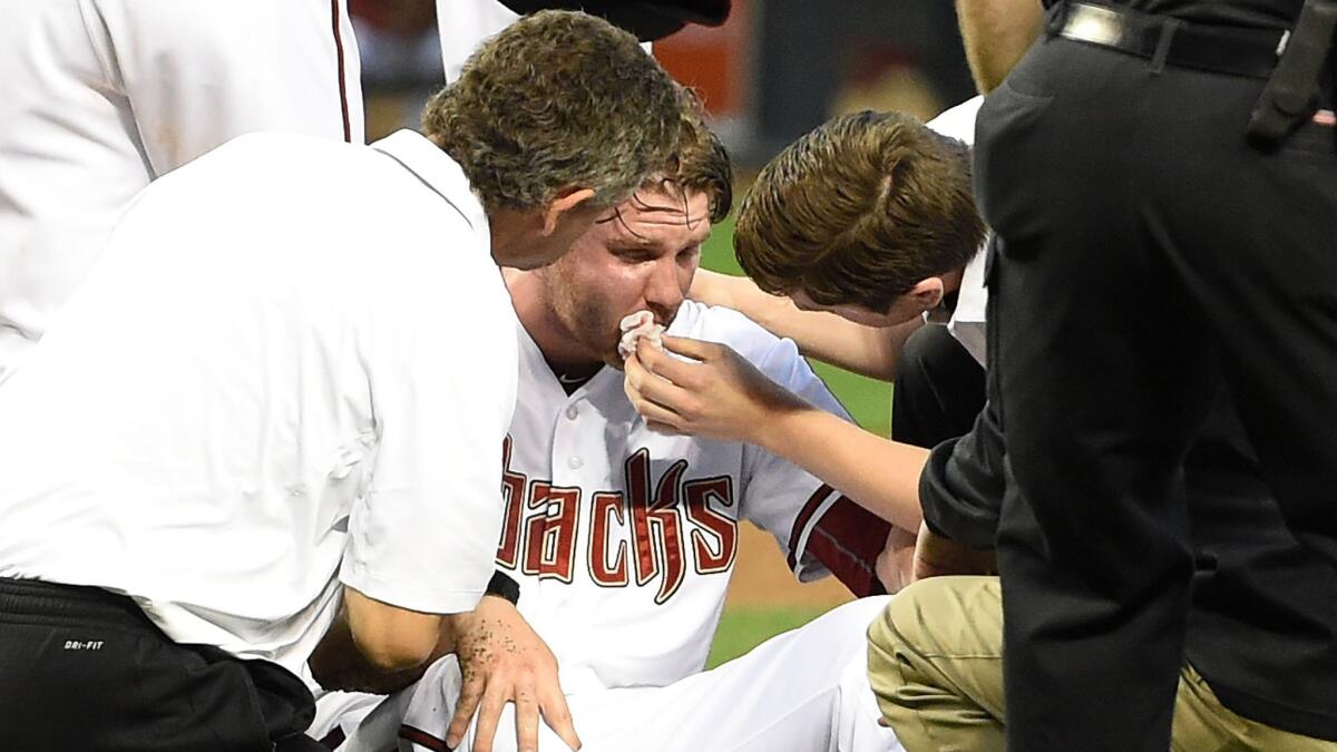 Arizona Diamondbacks pitcher Archie Bradley receives medical attention after taking a line drive off the right side of his face during a win over the Colorado Rockies in Phoenix on April 28.