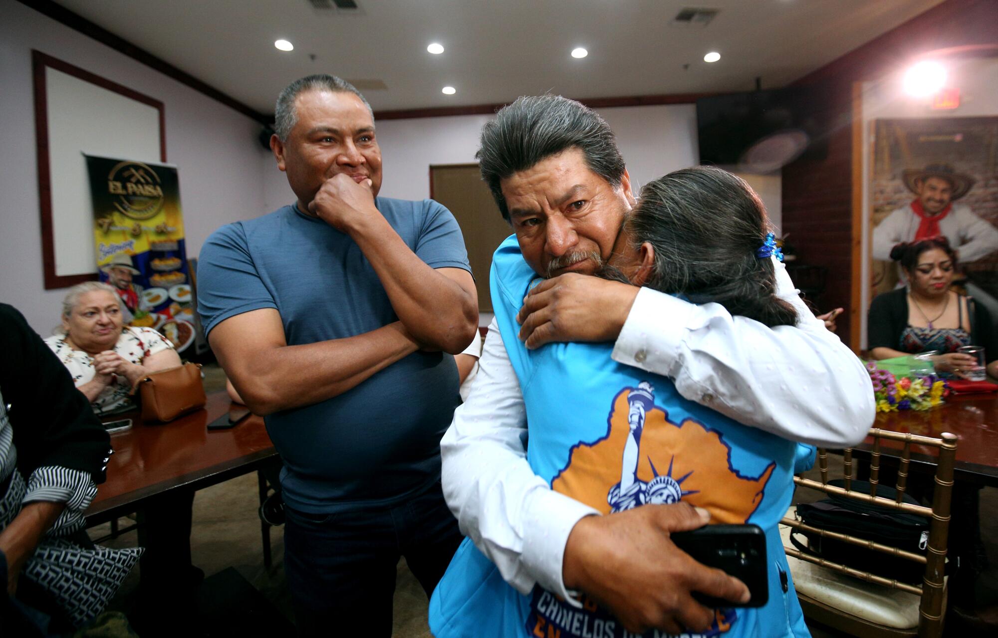Onlookers smile as Felicitas Ramos, 78, hugs her son.