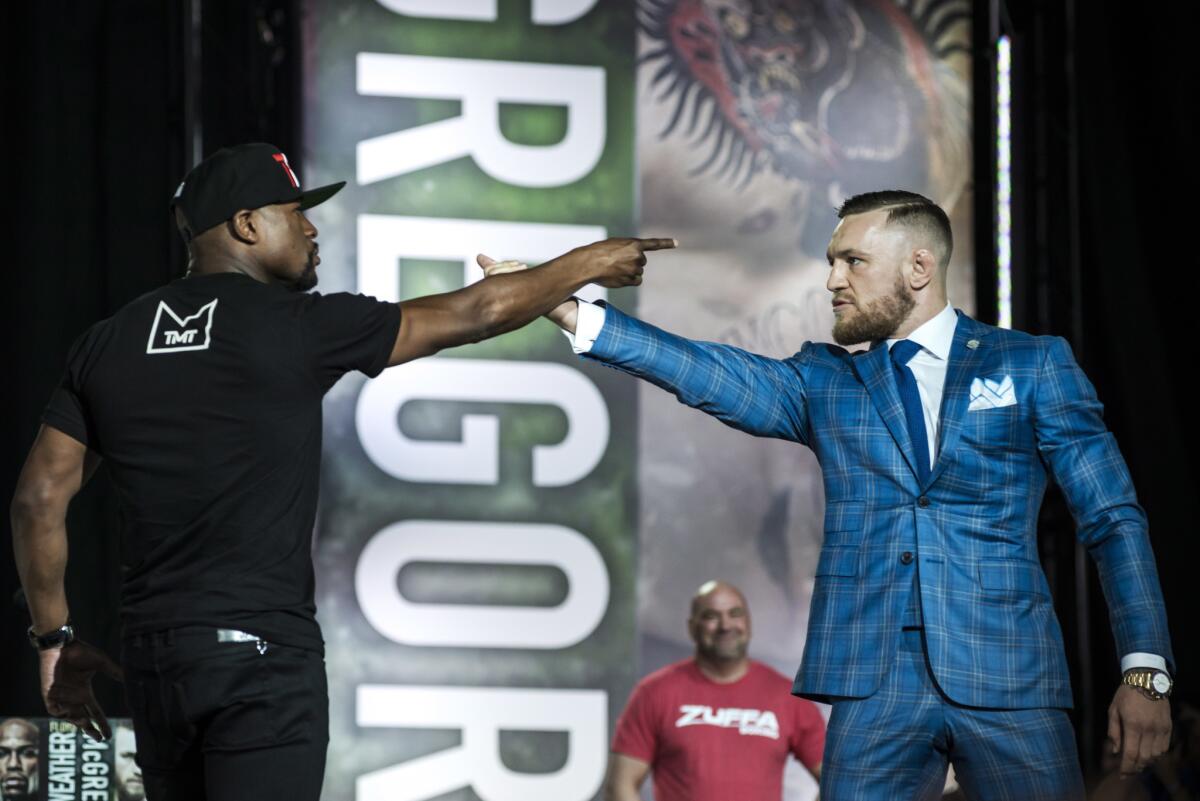 Floyd Mayweather Jr., left, and Conor McGregor exchange verbal jabs during a promotional stop in Toronto last month.