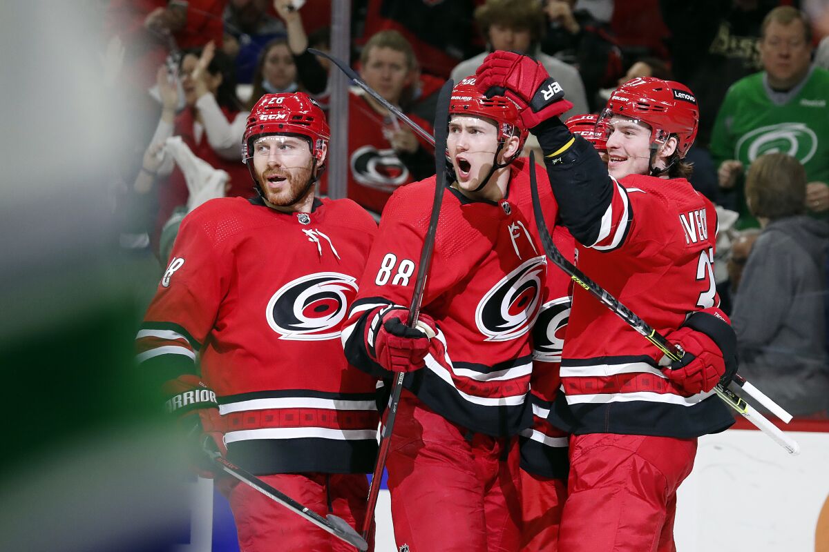Carolina Hurricanes' Martin Necas (88) celebrates his goal with teammates Ian Cole (28), left, and Andrei Svechnikov (37) during the second period of an NHL hockey game against the Vancouver Canucks in Raleigh, N.C., Saturday, Jan. 15, 2022. (AP Photo/Karl B DeBlaker)