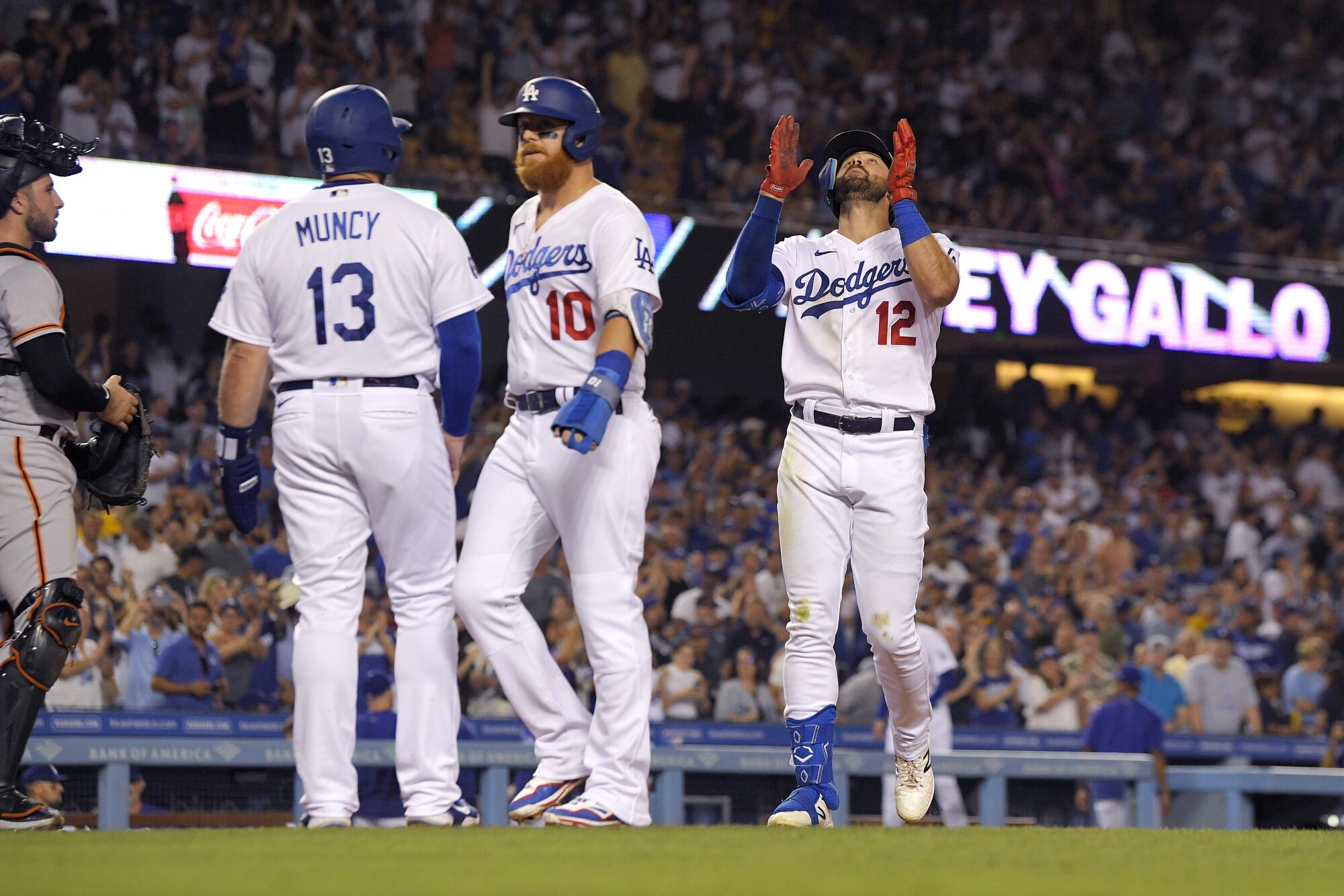 Joey Gallo, right, gestures as he scores after a three-run home run as Max Muncy and Justin Turner wait for him