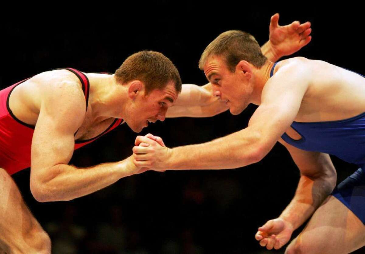 The IOC's decision to drop wrestling from the Olympics "might just awaken a sleeping giant," said former Olympic gold medalist Cael Sanderson, right, shown in a 2004 match against Malkaz Jorbenadze of the Republic of Georgia.