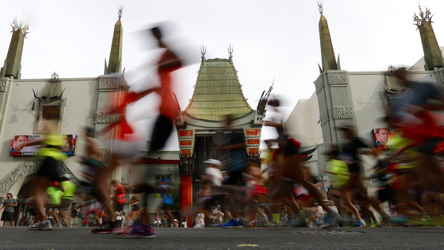 Runners pass TCL Chinese Theatre along Hollywood Blvd. during the 30th Los Angeles Marathon.