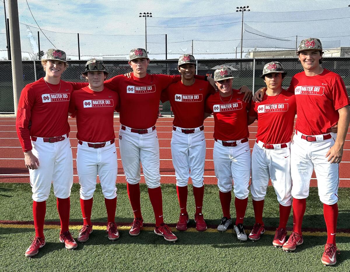 Seven Mater Dei baseball players who also umpire youth baseball games pose for a photo.