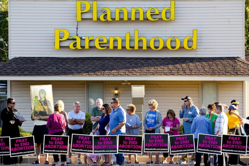 People protest outside of Planned Parenthood on Wednesday in Jackson, Mich. Participants sang and prayed to end abortion and close Planned Parenthood.
