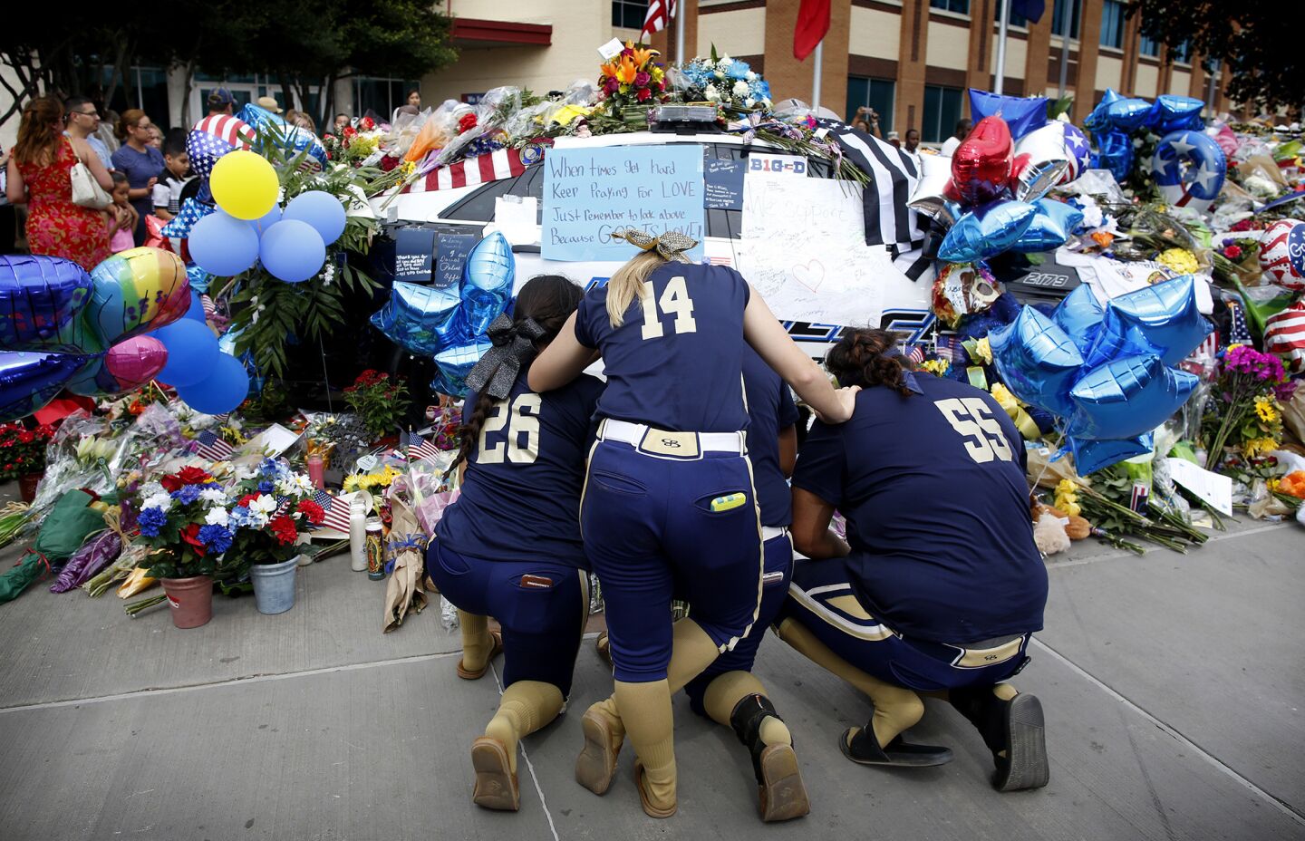 The MVPz, a Central Texas, Softball Team, pray in front of the Dallas Police Headquarters.
