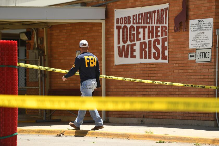 Uvalde, Texas May 25, 2022- An FBI agent walks by the outside of Robb Elementary School in Uvalde, Texas Wednesday. Nineteen students and two teachers died when a gunman opened fire in a classroom yesterday. (Wally Skalij/Los Angeles Times)