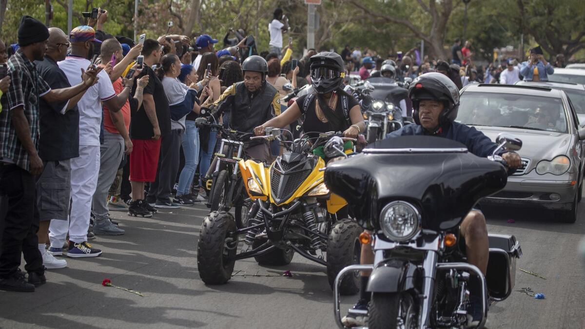 Vehicles join the procession for Nipsey Hussle near the Watts Towers Arts Center.