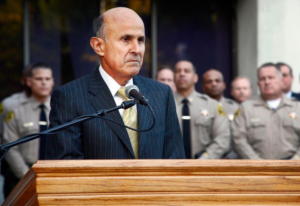 Los Angeles County Sheriff Lee Baca takes questions from the media after the FBI released results of a federal probe Dec. 9 at a news conference in Los Angeles.