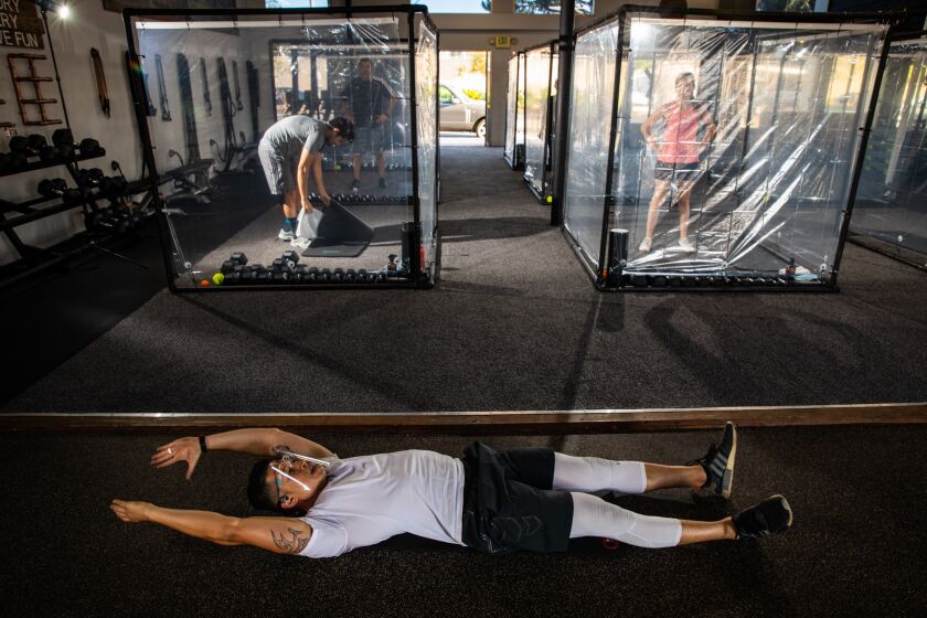 REDONDO BEACH, CA - JUNE 17: Peet Sapsin directs clients inside their "Gainz Pods," during his "HIIT" class, which stands for high intensity interval training, at Sapsin's Inspire South Bay Fitness, in Redondo Beach, CA, on Wednesday, June 17, 2020. Sapsin's wife Trinh came up with the pod idea and after researching costs, realized they could build what they needed for safety and distance with PVC piping and shower curtains. The couple build nine of their "Gainz Pods" for the studio, conducting in-person classes and still doing some Zoom classes. (Jay L. Clendenin / Los Angeles Times)