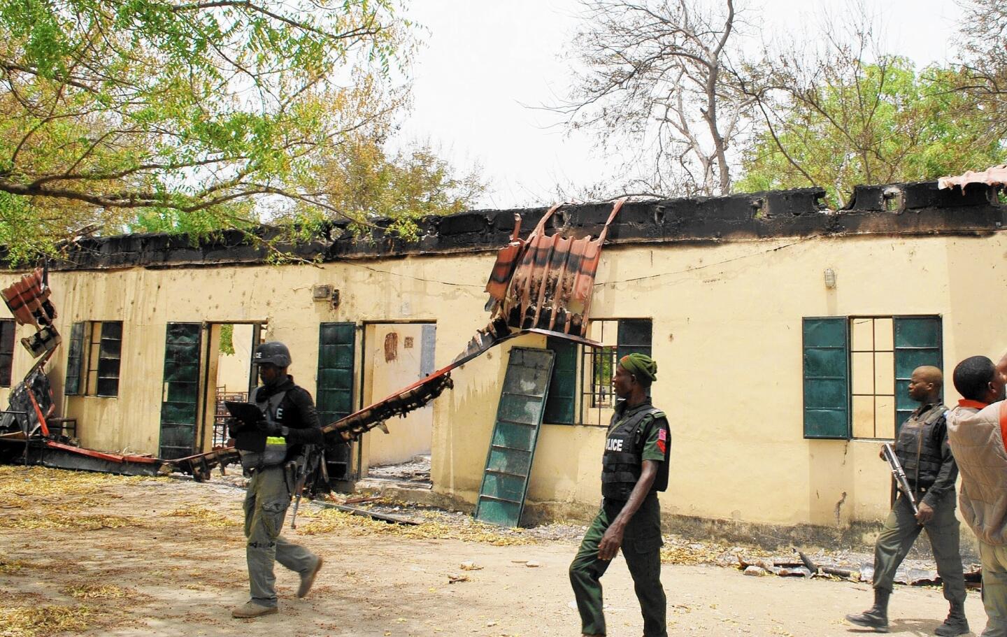 Police walk past the school in Chibok, Nigeria, where Boko Haram militants abducted more than 300 girls.