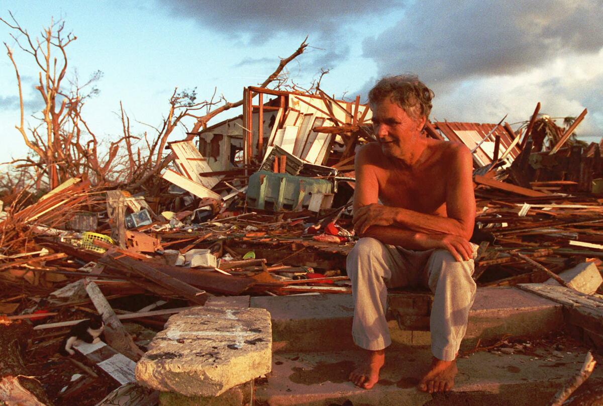 Janny Vancedarfield sits in front of debris from his house, which was destroyed by Hurricane Andrew in August 1992.