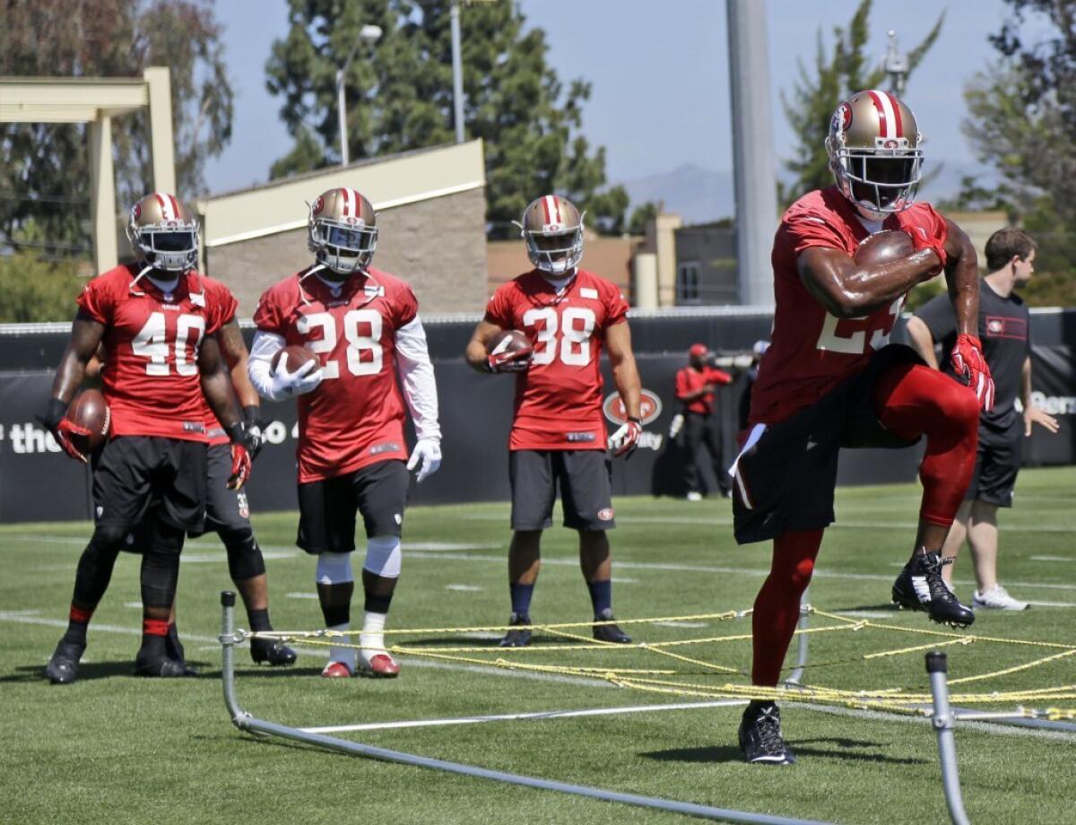 49ers running back Reggie Bush, right, goes through drills during an NFL football minicamp.