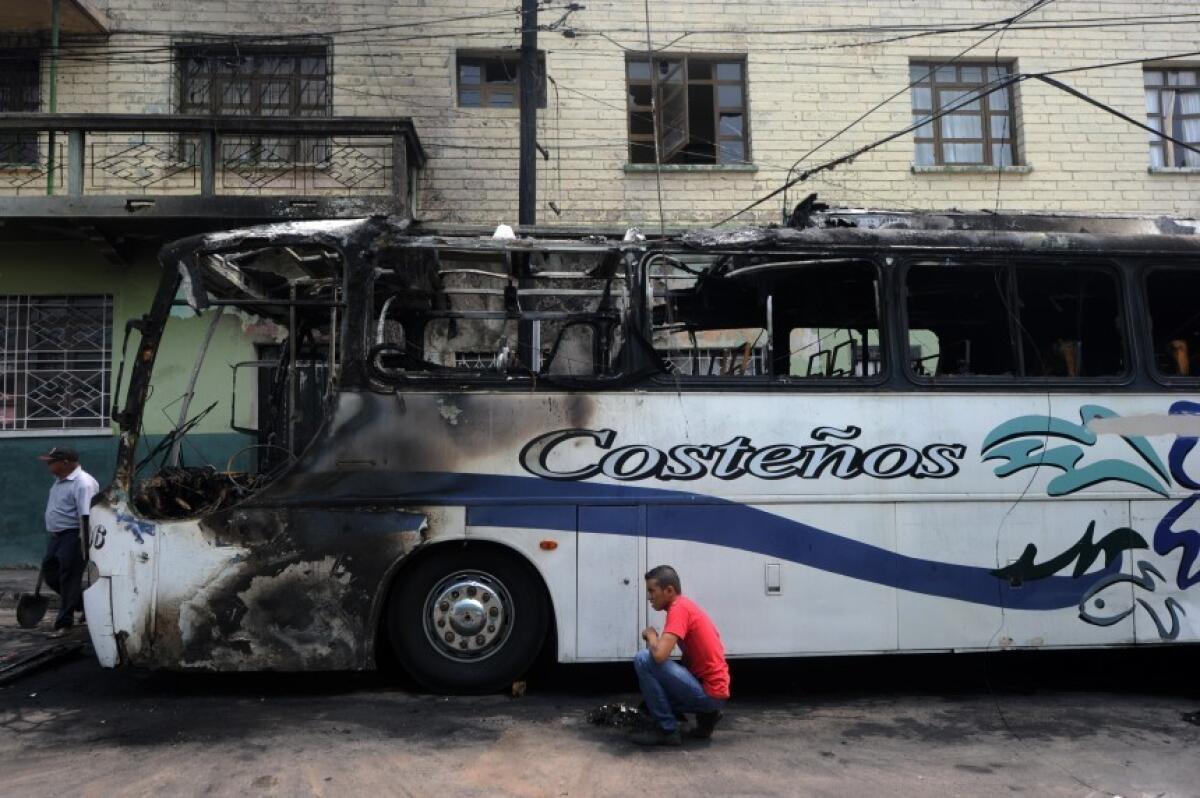 Un hombre observa un autobús que fue incendiado por pandilleros luego de que el chofer se rehusara a pagar el ‘impuesto de guerra’, en Tegucigalpa.