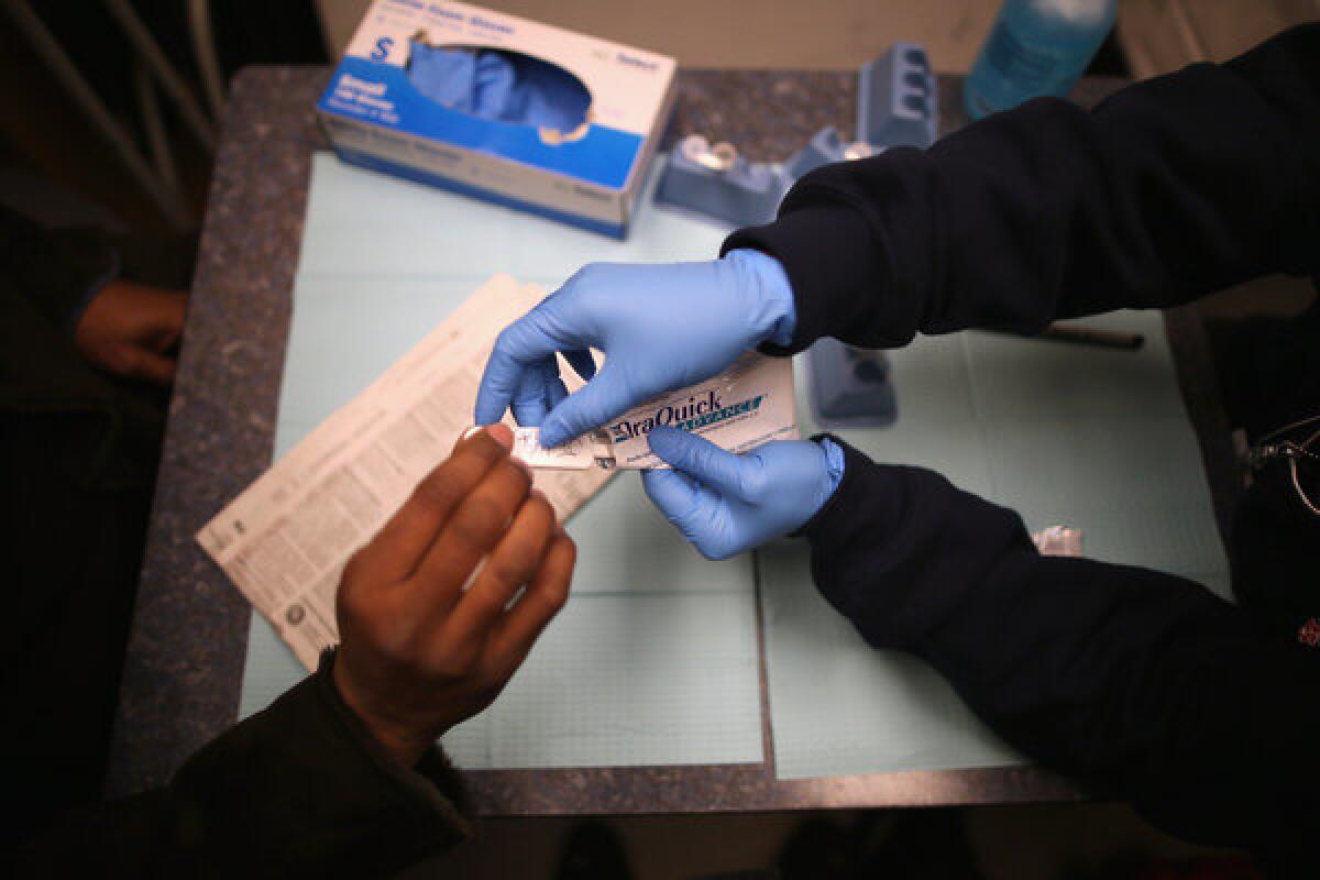 An oral HIV test kit is handed to a visitor at a mobile clinic. Thousands of dental patients in Oklahoma are being urged to be tested for HIV and hepatitus B and C.