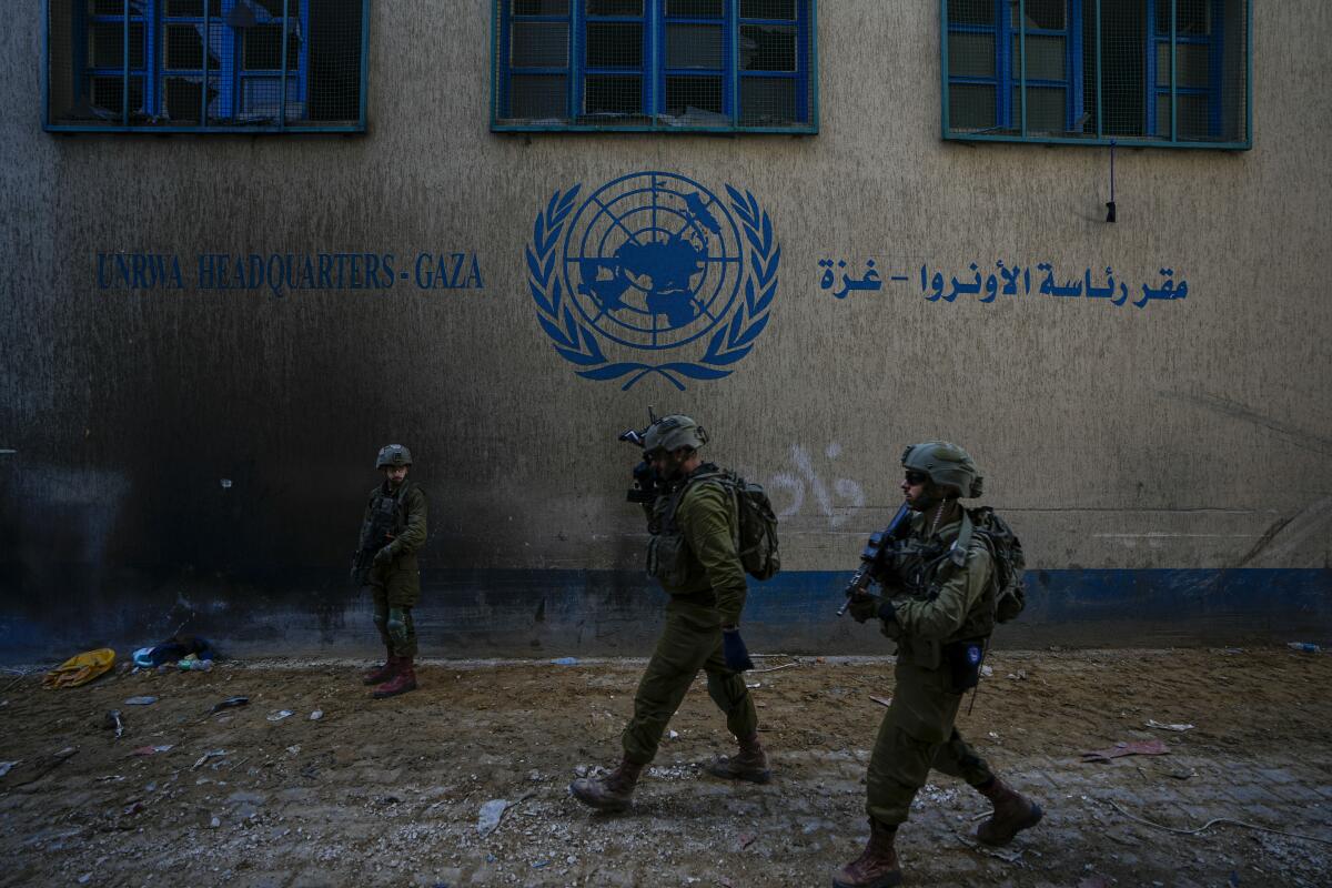 Israel soldiers outside a building with a U.N. emblem