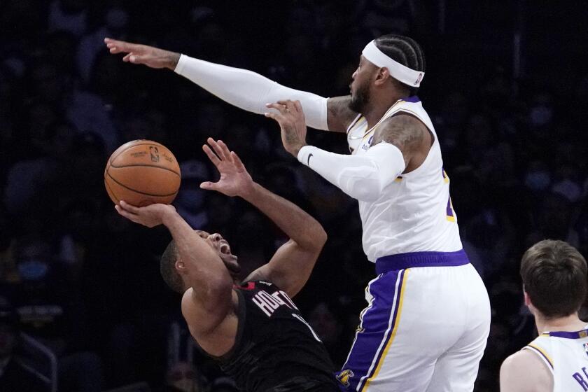Houston Rockets guard Eric Gordon, left, shoots as Los Angeles Lakers forward Carmelo Anthony.