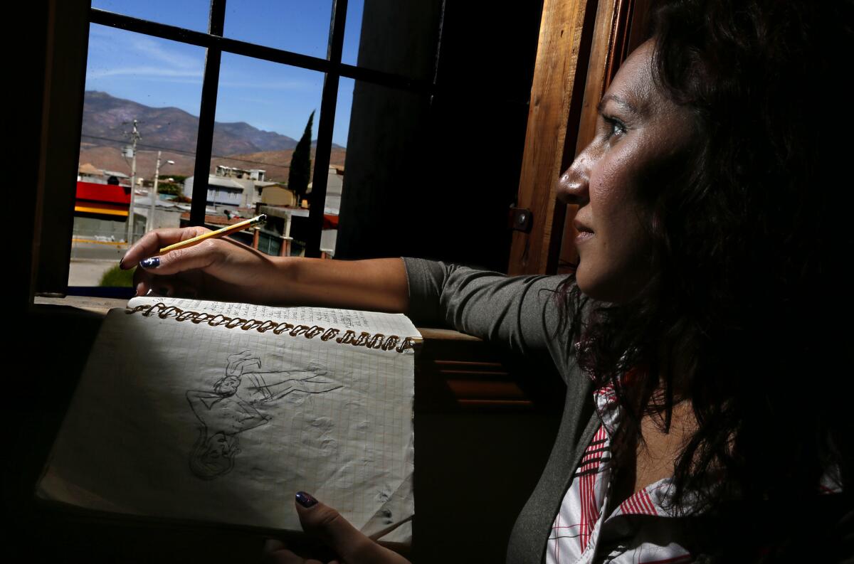 Emma Sanchez Paulsen works on illustrations for "The Little Elf," the story she has written for her sons trying to explain deportation. Out her window, she gazes toward the hills of the U.S./Mexico border, where her family is waiting for her.