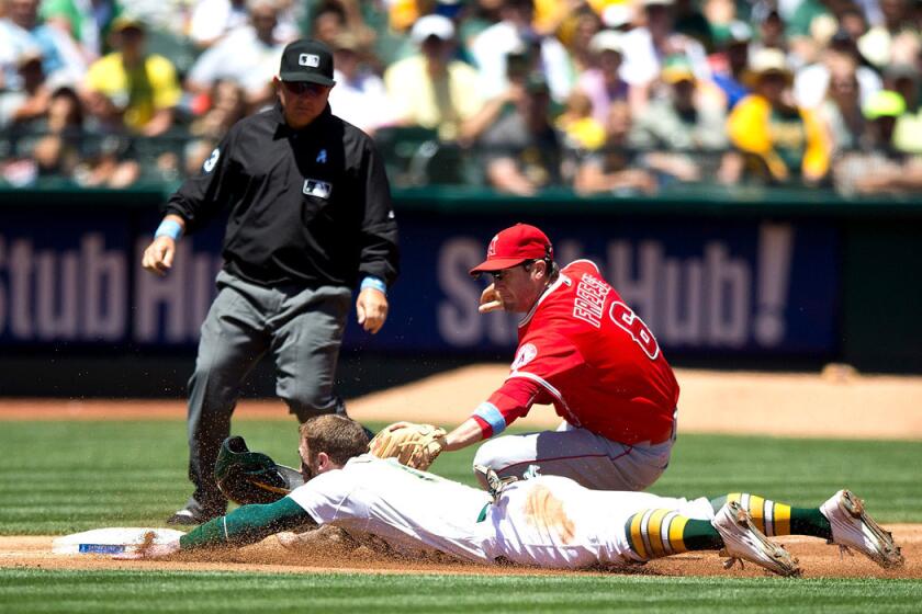 Oakland Athletics' Brett Lawrie is tagged out attempting to steal third base by Los Angeles Angels of Anaheim's David Freese in front of umpire Greg Gibson during the second inning on Sunday. A's beat the Angels, 3-2.