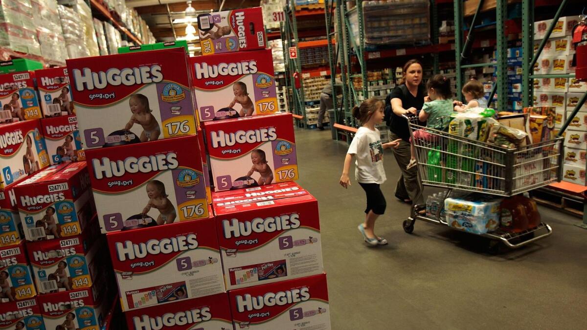 A family passes by bulk packages of diapers at a Costco store in Tucson.
