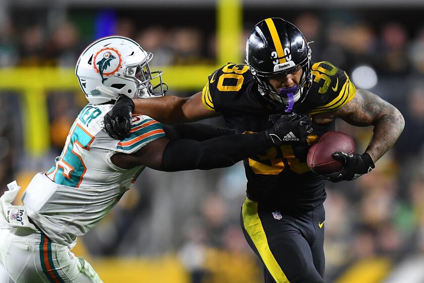 PITTSBURGH, PA - OCTOBER 28: James Conner #30 of the Pittsburgh Steelers is wrapped up by Jerome Baker #55 of the Miami Dolphins during the fourth quarter at Heinz Field on October 28, 2019 in Pittsburgh, Pennsylvania. (Photo by Joe Sargent/Getty Images)