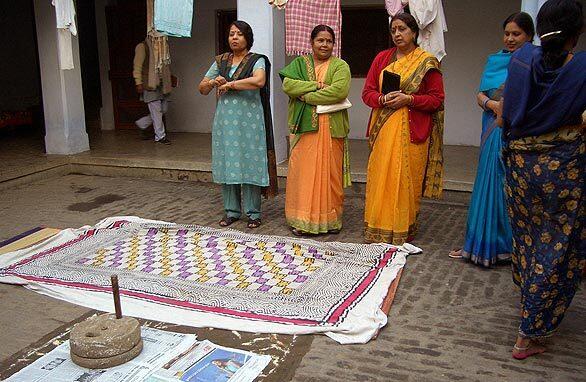 Women gather in the courtyard of Garima Upadhya's parents' home in Gorakhpur, India, to perform a ceremony in which wheat is ground. This was one of six days of ceremonies leading up to her wedding to Vishal Choubey.