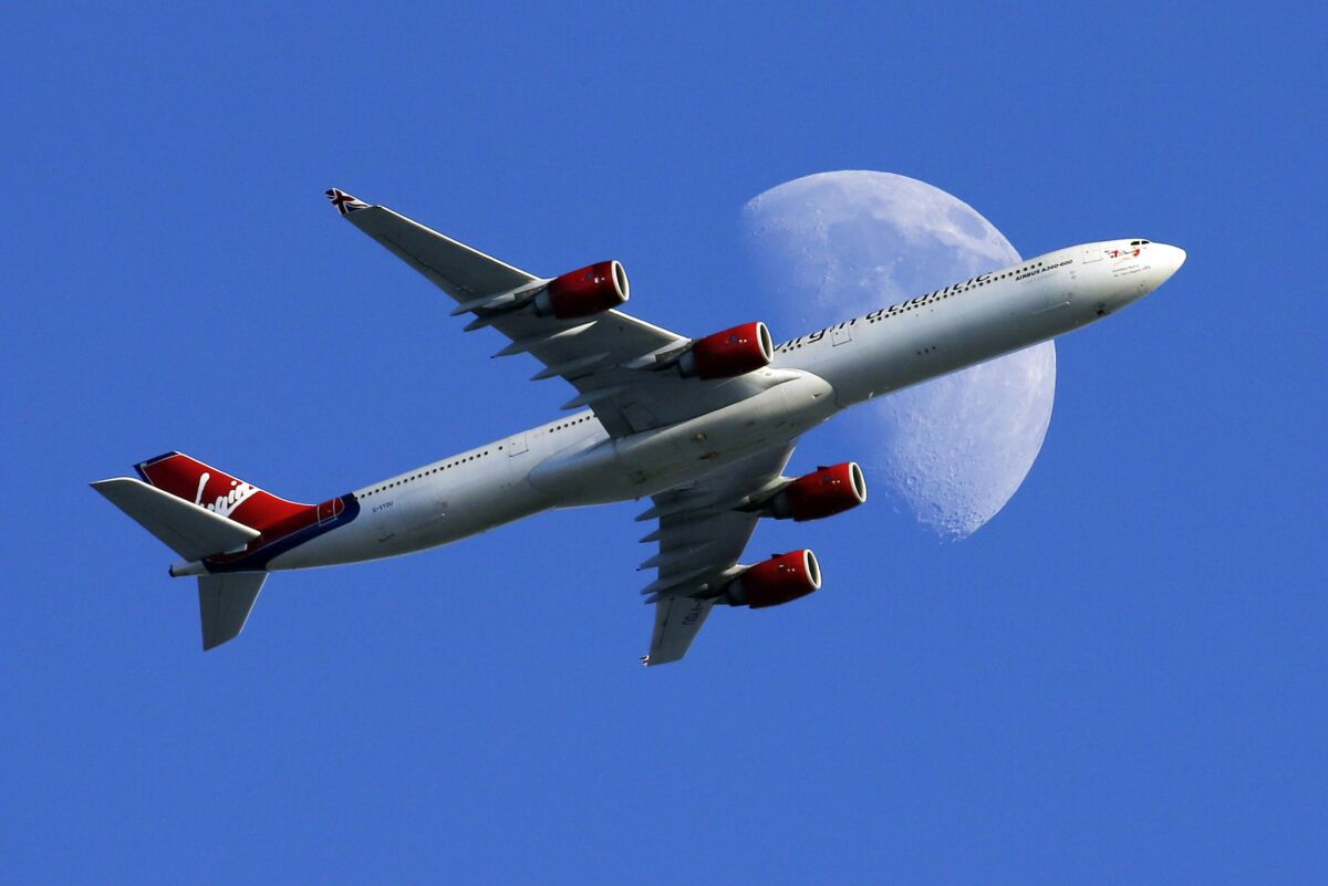 A Virgin Atlantic passenger jet crosses a gibbous moon on its way to Los Angeles International Airport.
