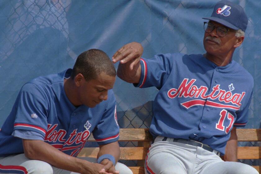 Montreal Expos manager Felipe Alou speaks with his son, Expos outfielder Moises Alou, while watching the team's intra-squad game in West Palm Beach, Fla. Friday, March 1, 1996. The Expos start their Grapefruit League season against the Atlanta Braves on Saturday.(AP PHOTO/Ryan Remiorz) ORG XMIT: WPB103