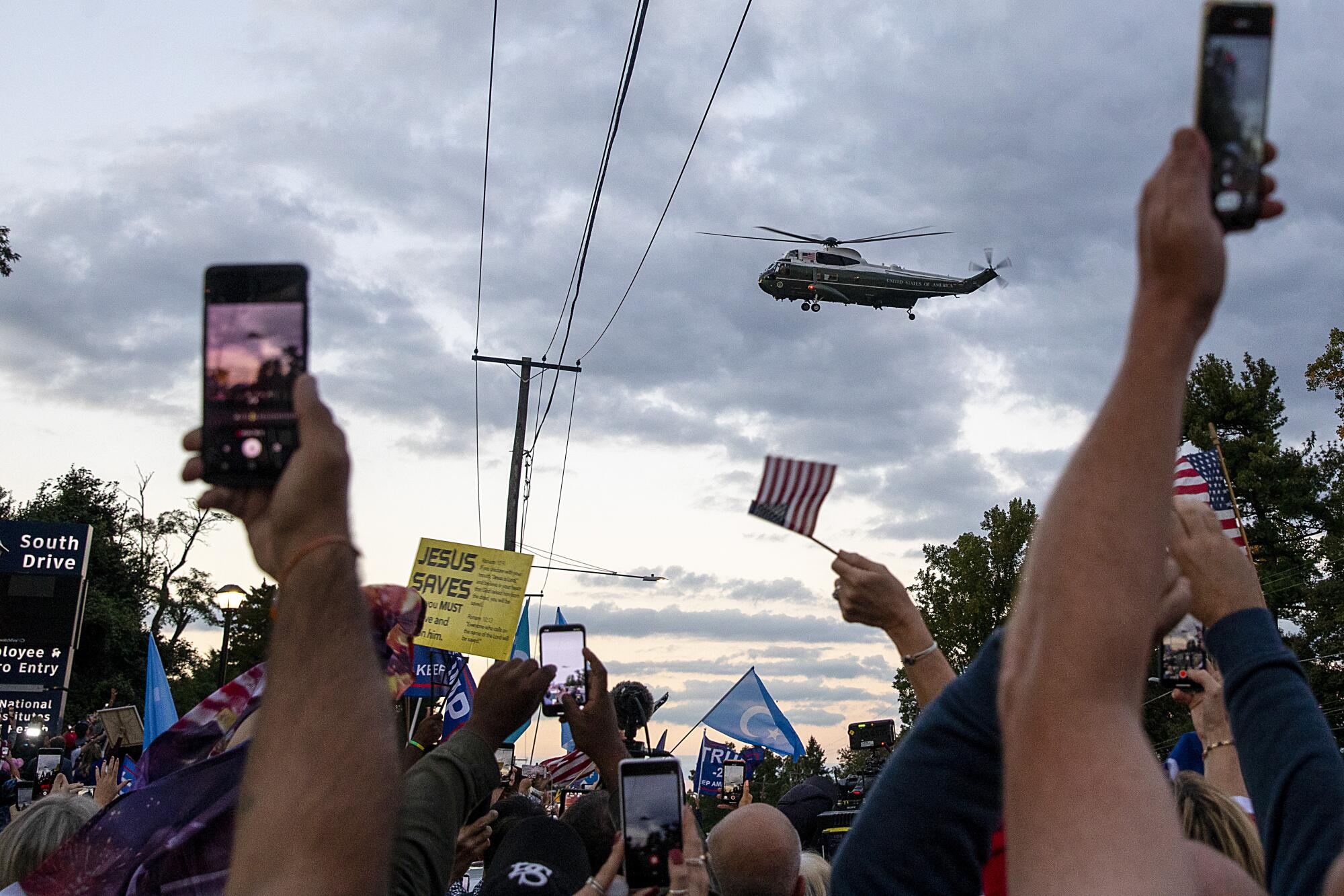 Marine One flies over a crowd of President Trump's supporters.