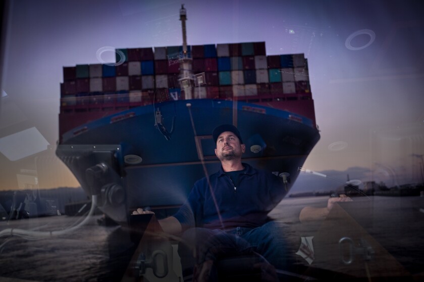 Port of Long Beach, CA - December 03: Capt. Mike Johnson reflected in the wheelhouse of the tugboat Delta Teresa where he has a front-row seat to the size and the scale of the container ship that he's helping to bring into the port of Long Beach Friday, Dec. 3, 2021 in Port of Long Beach, CA. (Allen J. Schaben / Los Angeles Times)