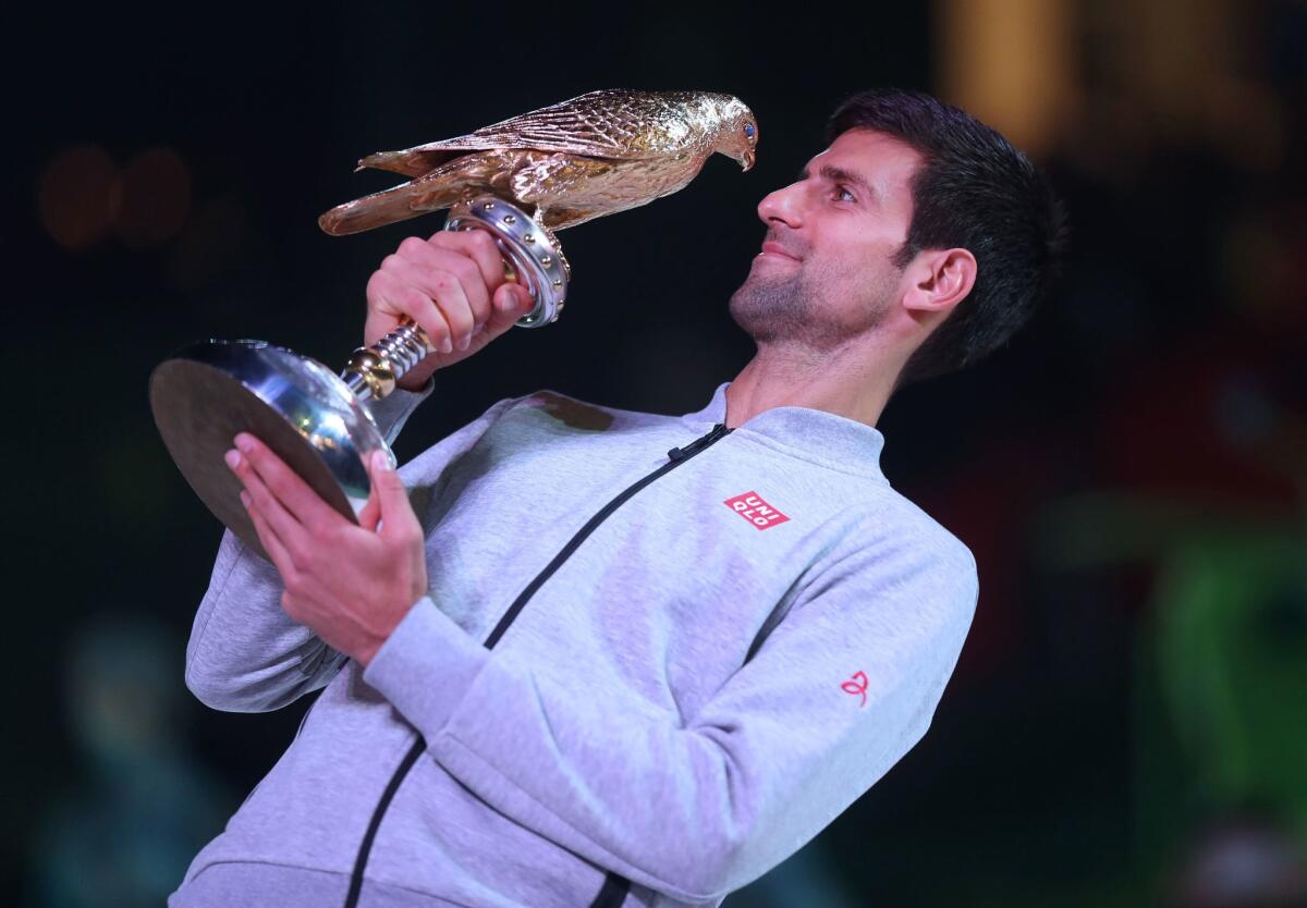 Novak Djokovic with the winner's trophy after beating Britain's Andy Murray during their final tennis match at the ATP Qatar Open in Doha on January 7, 2017.