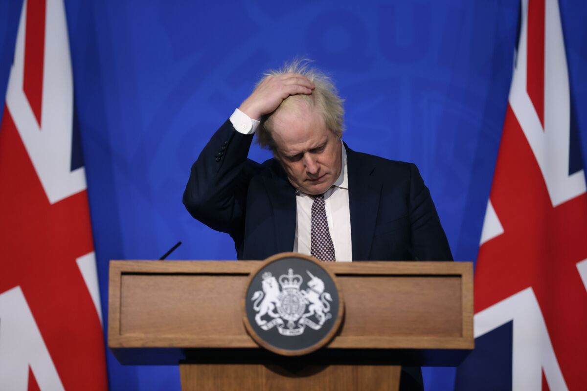 FILE- Britain's Prime Minister Boris Johnson gestures as he speaks during a press conference in London, Saturday Nov. 27, 2021, after cases of the new COVID-19 variant were confirmed in the UK. British lawmakers will vote Tuesday, Dec. 14, 2921 on whether to approve new restrictions to curb the spread of the omicron variant of coronavirus — and many will have more than public health on their minds when they say yes or no. (Hollie Adams/Pool via AP, File)