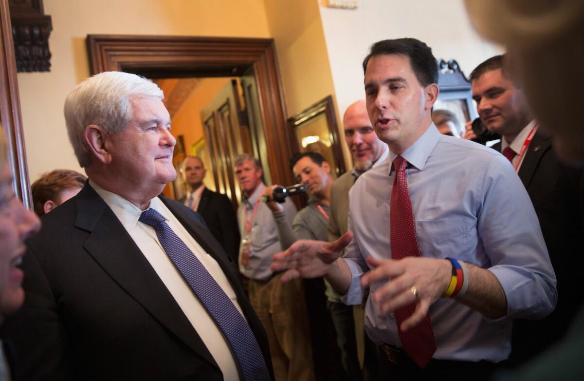 Former Speaker of the House Newt Gingrich speaks with Wisconsin Gov. Scott Walker at the Iowa Freedom Summit in Des Moines, Iowa, on Jan. 24.