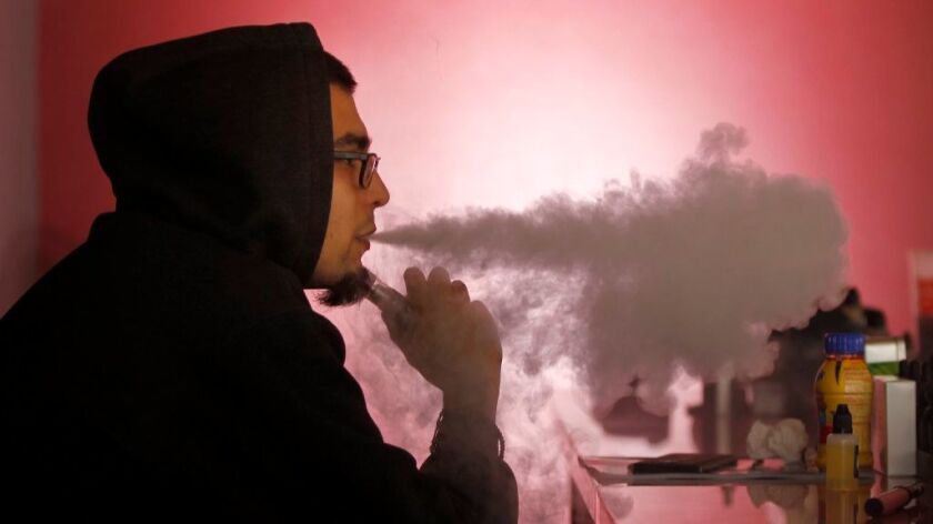 Carlos Carcenas, manager of Vapor Invasion in Grantville smokes an e-cigarette at the vape shop.
