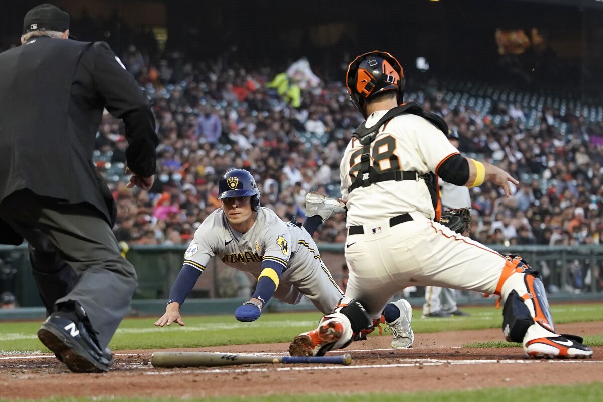 San Francisco Giants catcher Buster Posey, right, prepares to tag out Milwaukee Brewers' Luis Urias at home during the second inning of a baseball game in San Francisco, Wednesday, Sept. 1, 2021. (AP Photo/Jeff Chiu)