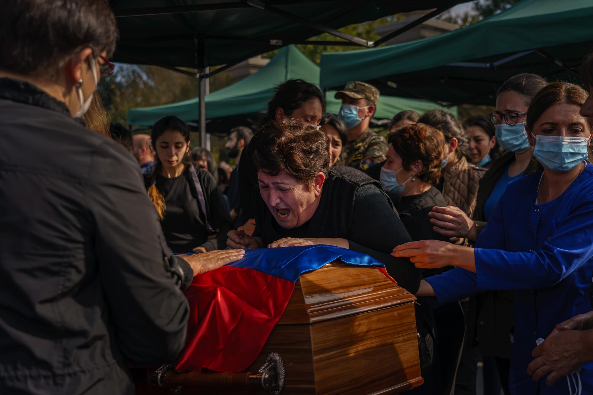 A woman wails over a casket at the funerals of Kristapor Artin and Suren Vanyan, volunteer fighters for Armenia.