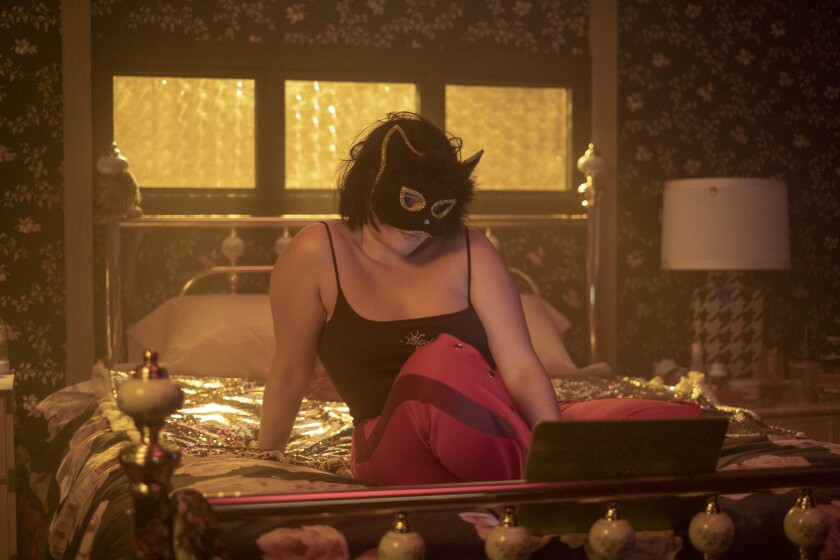 Barbie Ferreira, sitting on a bed, wears a cat mask as she works as a cam girl on "Euphoria."