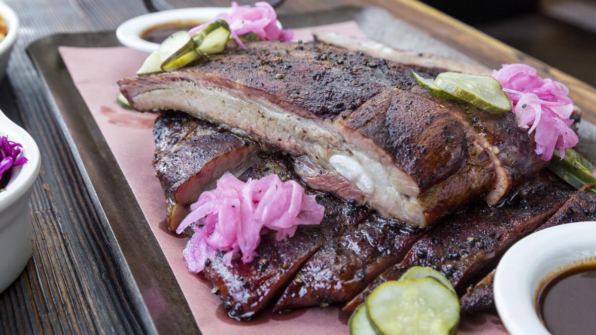 Full rack of pork spare ribs and side orders on the table at Maple Block Meat Co. in Culver City. (Ricardo DeAratanha / Los Angeles Times)